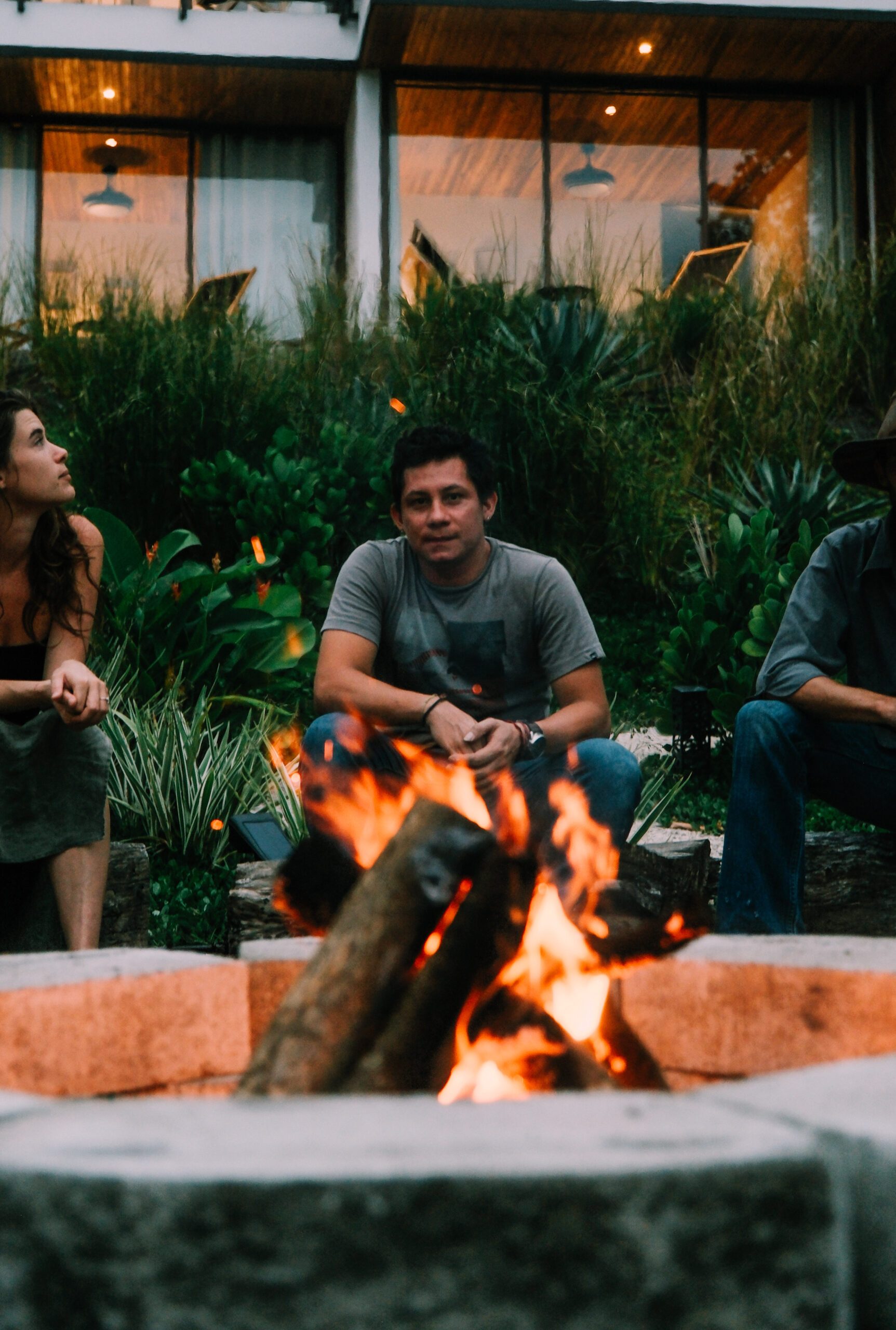 A man contemplating his trauma in front of a fire at ananda lodge's first responder retreats.
