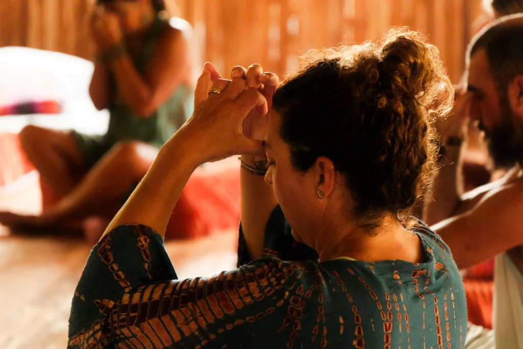 A woman practices a body scan during a trauma-informed somatic healing retreat group session.