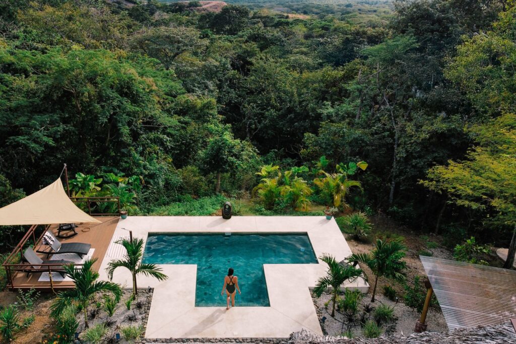 Woman about to step into an infinity pool overlooking the Costa Rican jungle during her peaceful retreat