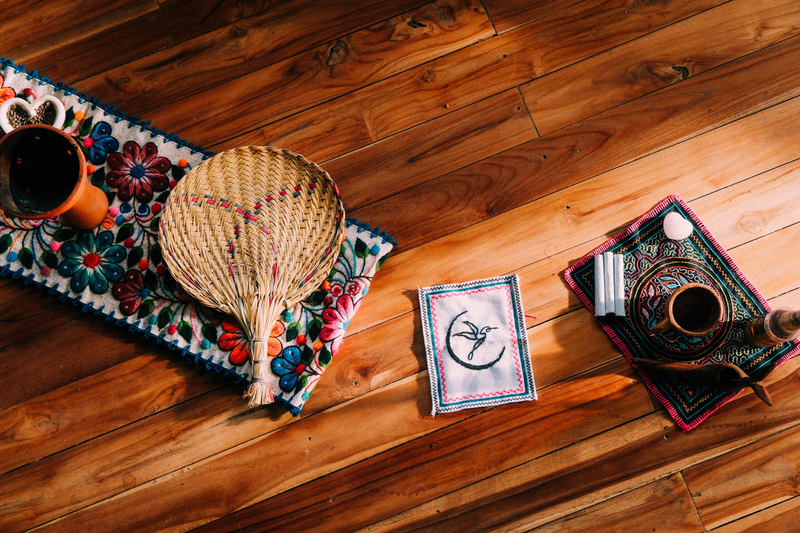 An array of items at a plant medicine retreat in Costa Rica, including ayahuasca, cacao, a fan, and fabric.