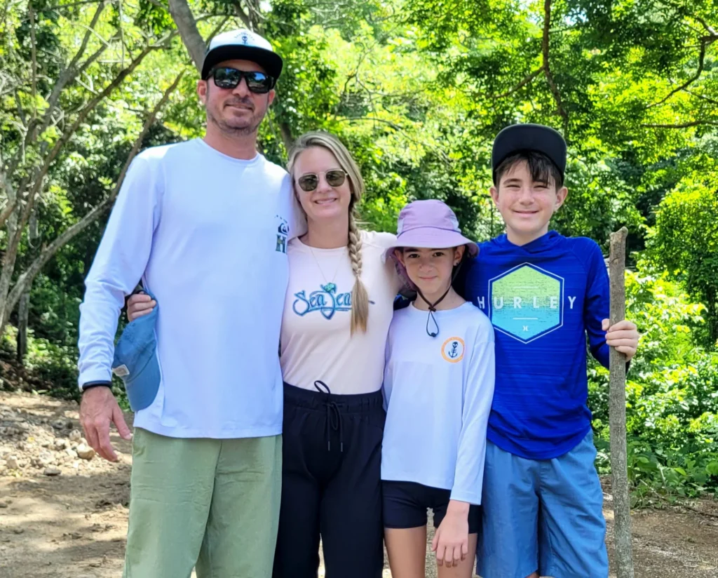 A family holding each other in front of the costa rica jungle