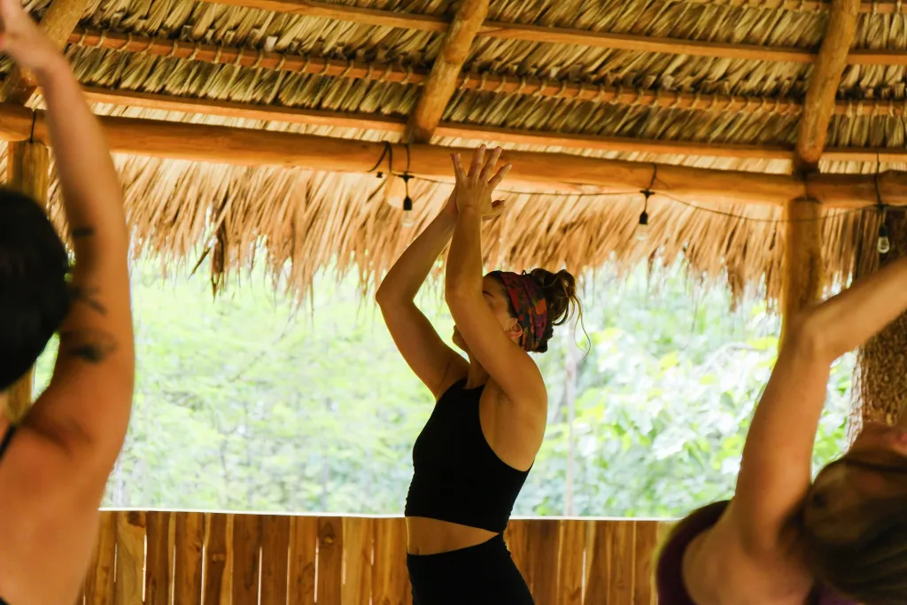 Empowered woman hosting a retreat, guiding participants through a transformational experience in a sacred natural setting