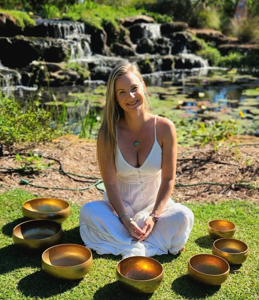 Smiling woman at Ananda Lodge with singing bowls after ceremony, embodying the clarity and peace found through ayahuasca experience stories